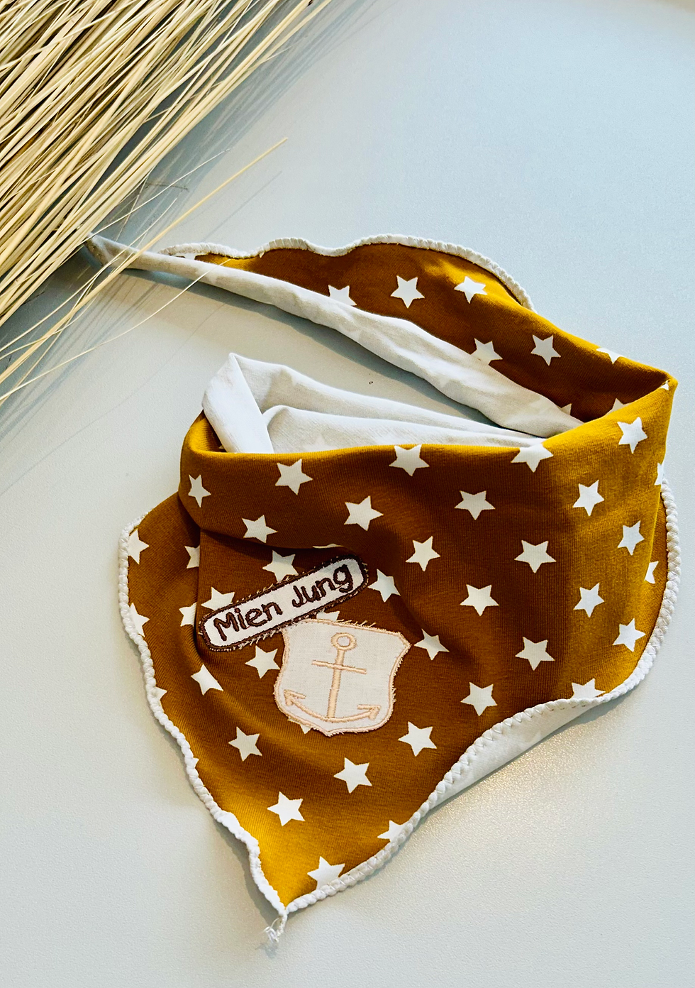 Miniaturbild: Handgefertigtes Halstuch aus Baumwolljersey in Senf mit Sternen und Stickapplikation Mien Jung und Anker