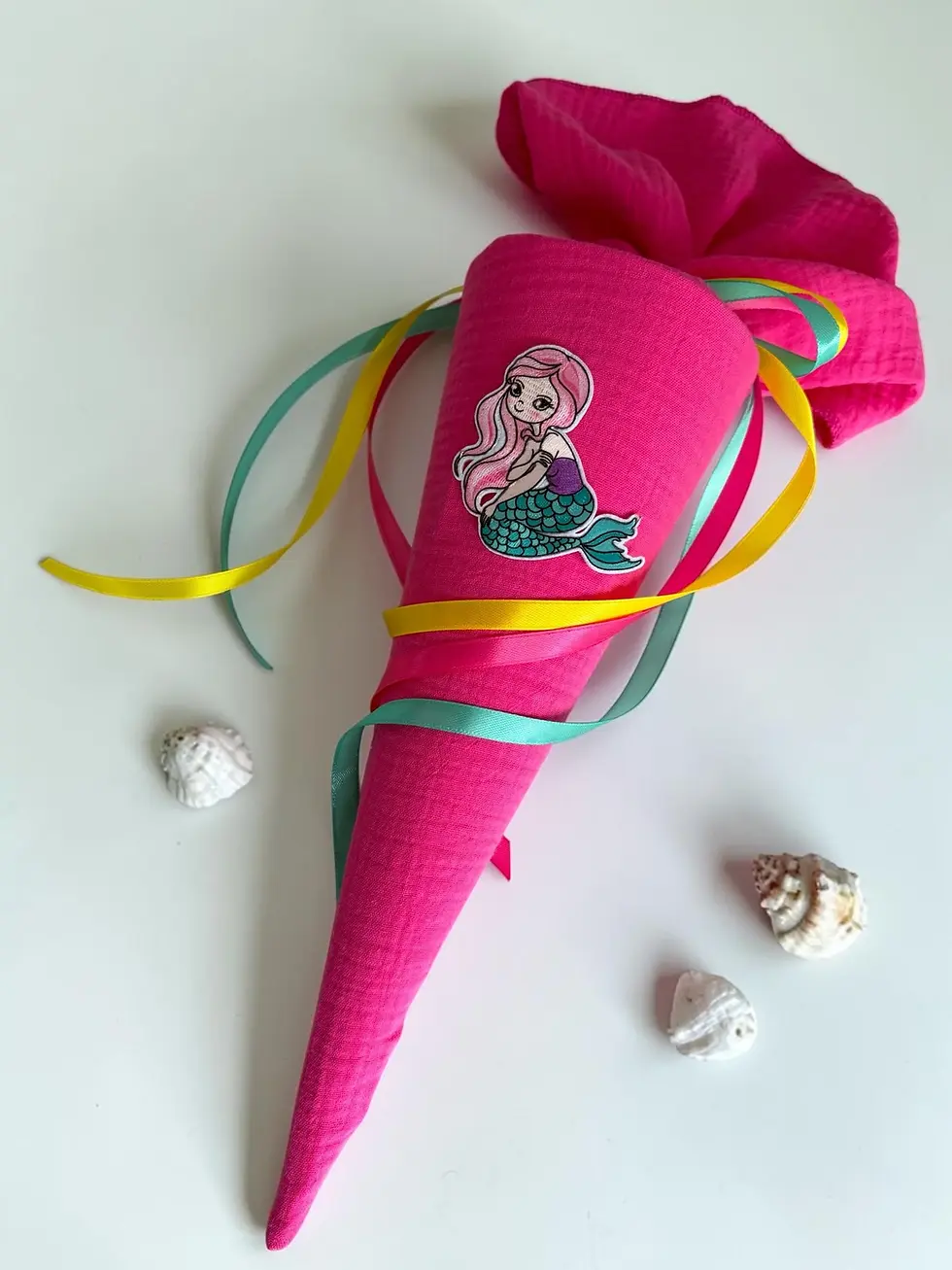 Personalisierbare Stoffschultüte in Pink mit Meerjungfrau-Motiv und bunten Satinbändern für einen besonderen Schulstart.