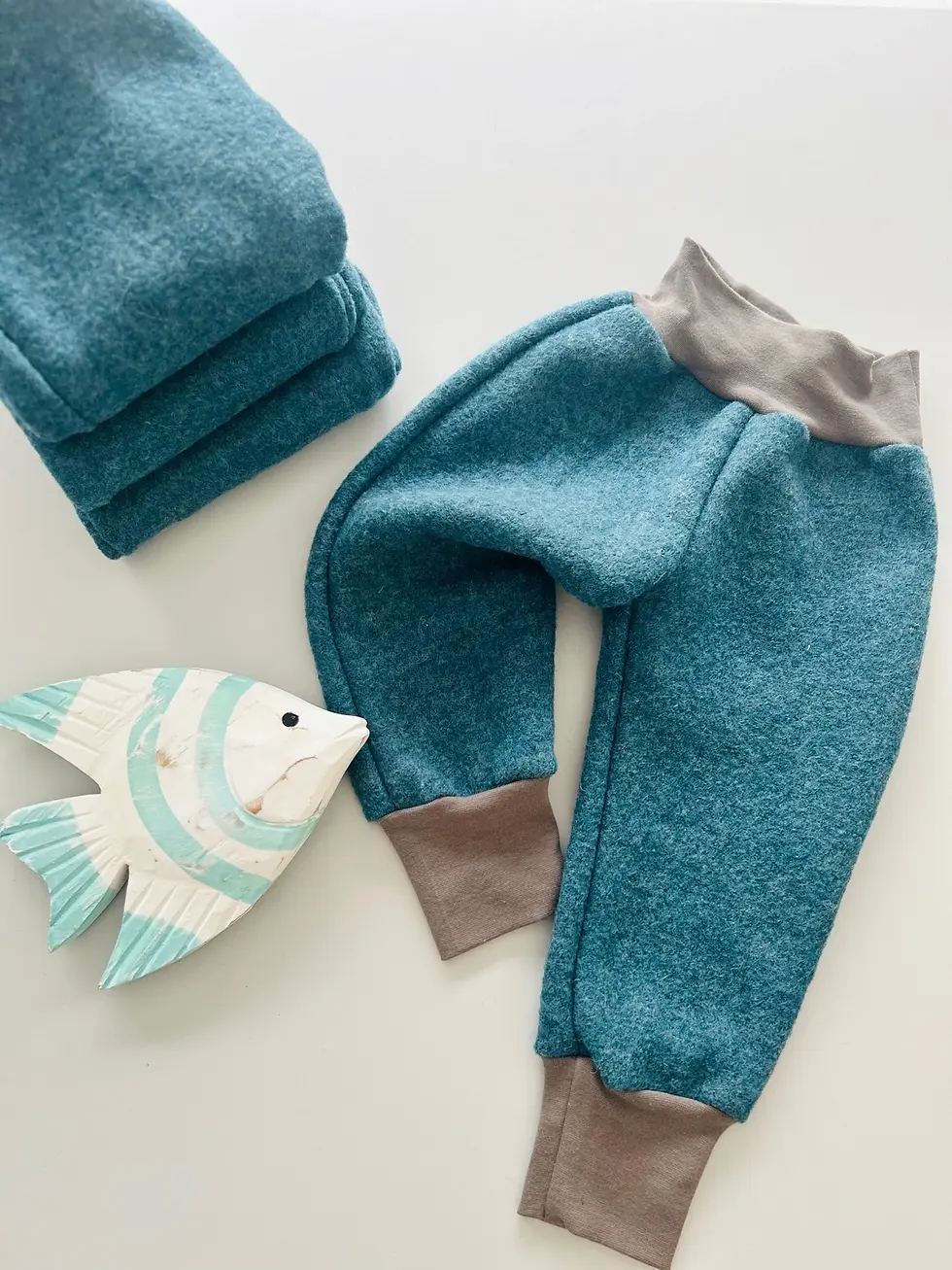 Baby-Walkhose in Petrol aus Wollwalk – handgemacht in Hamburg, mit Dino-Design und weichen Bündchen, OEKO-TEX® zertifiziert.