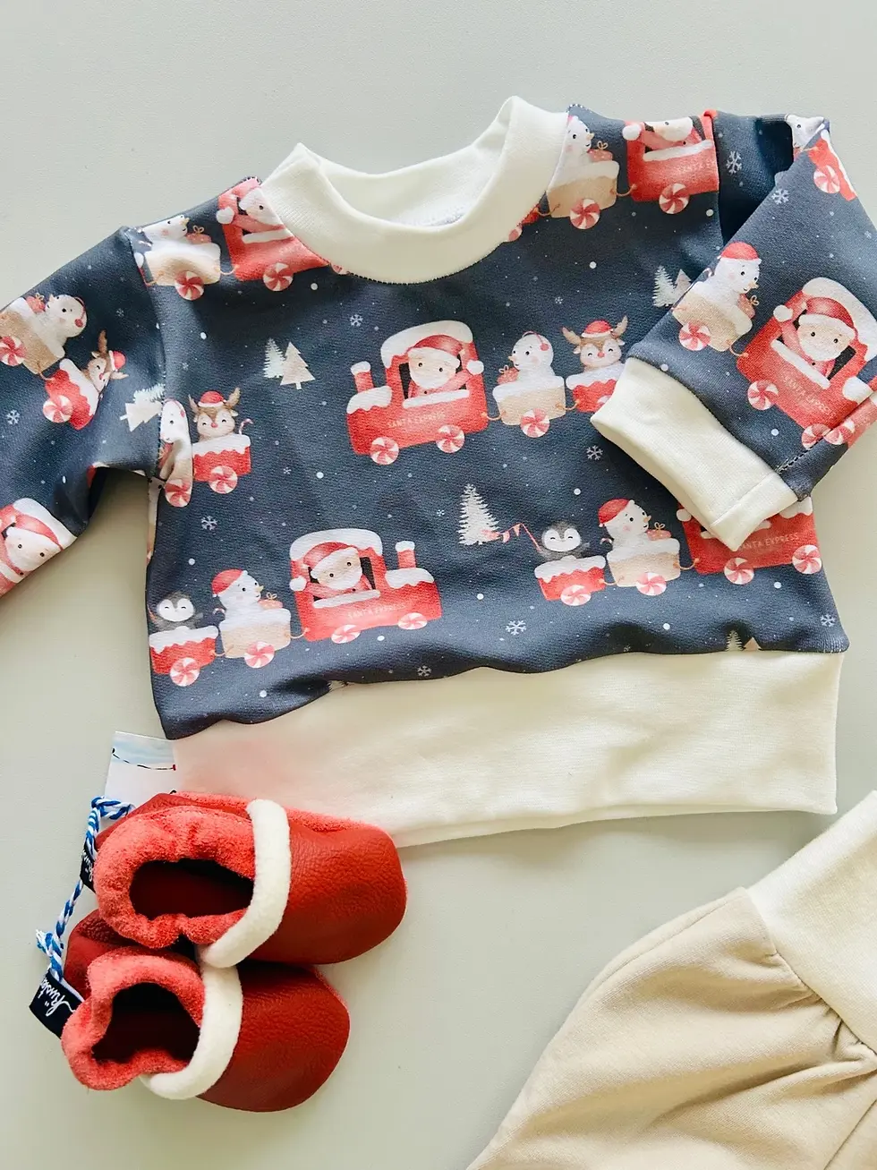 Miniaturbild: Baby-Weihnachtspullover Santa Express aus weichem OEKO-TEX-Jersey. Dunkelblau, winterliches Motiv, handgemacht in Hamburg.