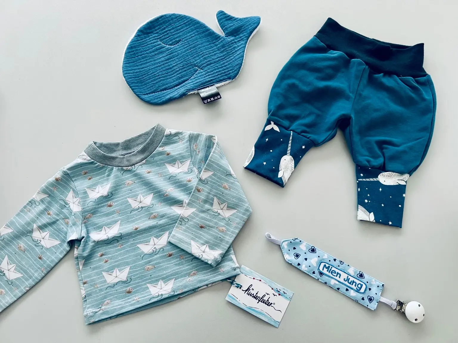 Maritimes Babyset in Petrol und Blau mit Papierboot-Shirt, Narwal-Hose und Wal-Waschlappen von Küstenfieber.