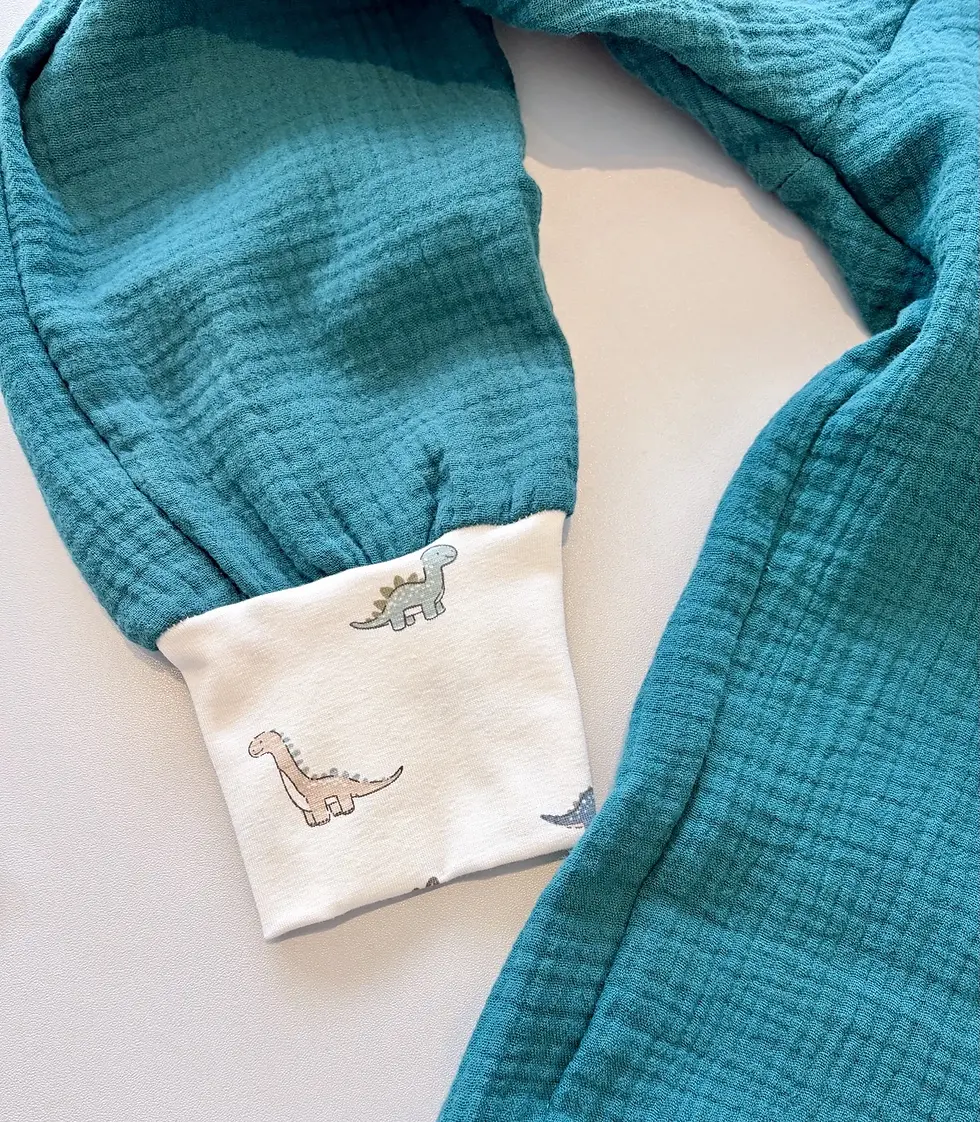 Detailaufnahme der Musselinhose Dino-Spaziergang in Petrol mit weichem Dino-Bündchen, mitwachsend und aus OEKO-TEX Baumwolle.