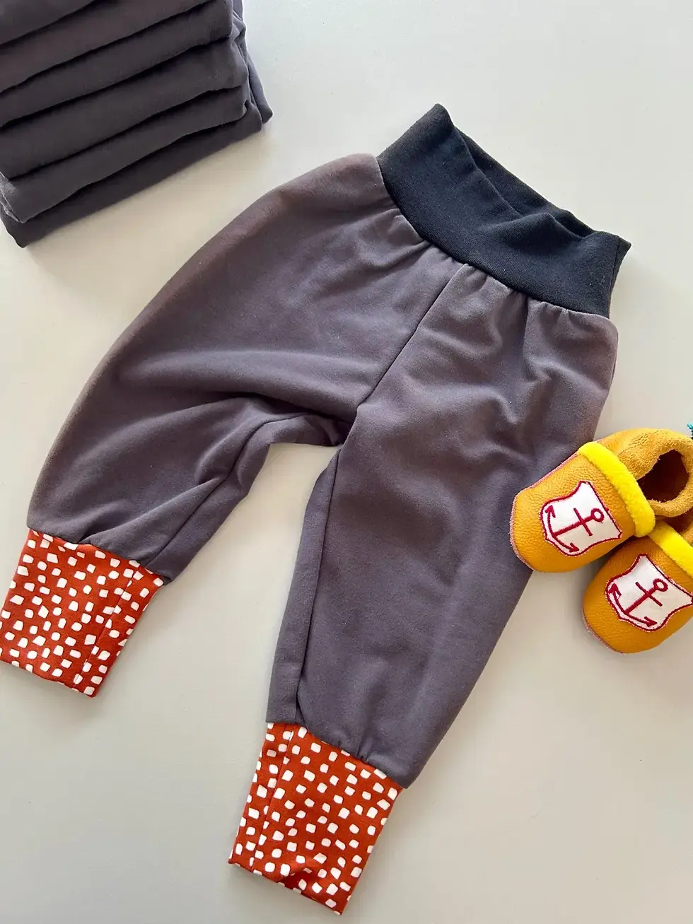 Mitwachsende Baby Pumphose Küstentanz aus Bio-Sweat in Grau mit rostfarbenen Bündchen – flachgelegt, handgemacht in Hamburg.
