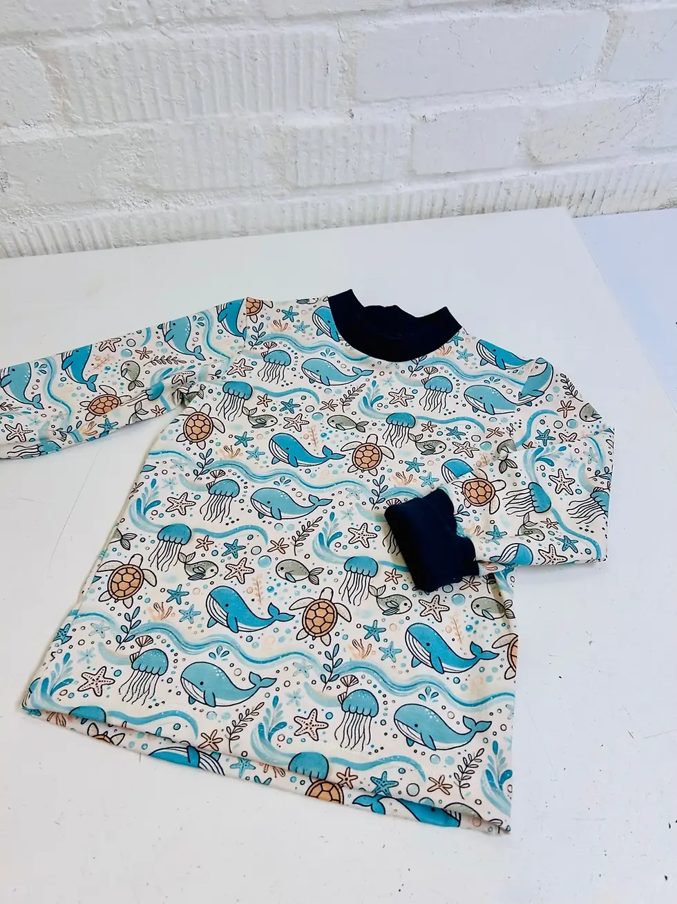 Miniaturbild: Detailbild Bündchen und Ausschnitt vom Langarmshirt Unterwasserfreunde, marineblaue Bündchen, hochwertig verarbeitet, handgem
