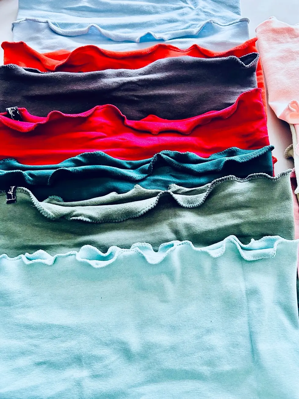Miniaturbild: Rostfarbener Kinderloopschal aus weichem Jersey, eng gerollt fotografiert. Elastisch, warm und hautfreundlich.