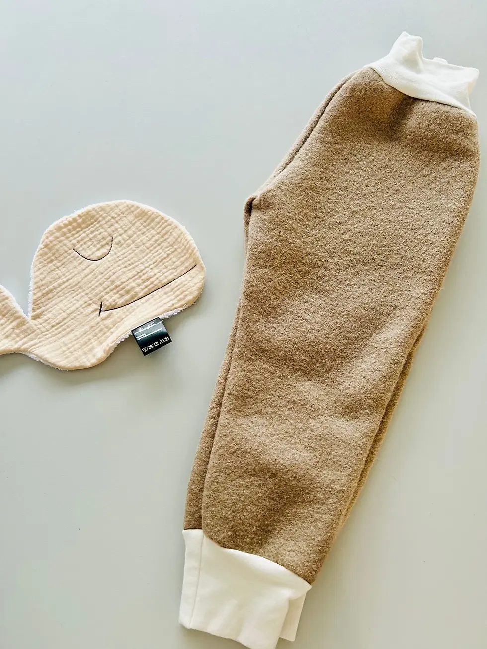 Miniaturbild: Seitenansicht der Walkhose aus Wollwalk in Beige mit weichen Bündchen in Creme, bequemer Schnitt, mitwachsend und handgemacht