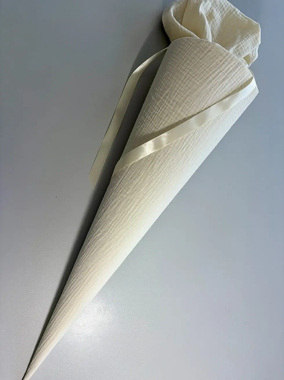 Miniaturbild: Schlichte Schultüte aus cremefarbenem Musselin mit langem Satinband. Handgefertigte Stoffschultüte im minimalistischen Skandi