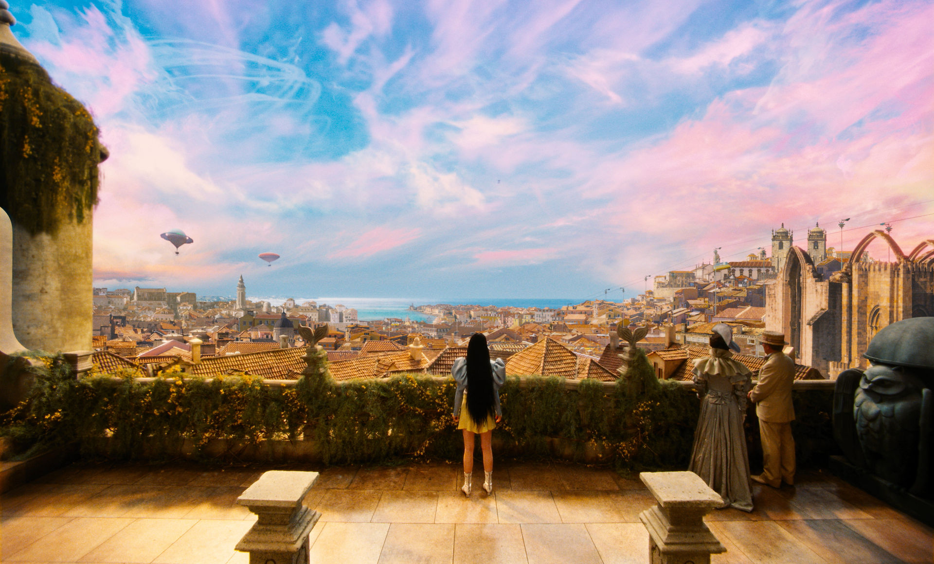 woman standing on a balcony looking at a colour saturated city