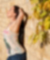 Ruth Ramsay, Adult Sex Educator and Coach, in an Amnesia Ibiza vest and blue jeans sun worshiping against a wall