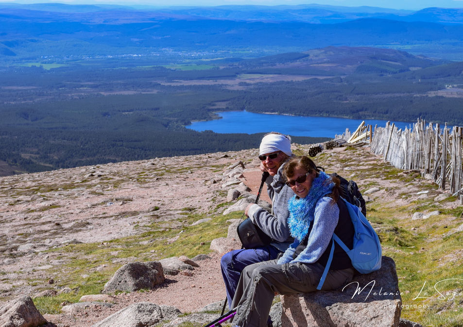 Walkers taking a break in Cairngorms National Park with Aviemore in the background, Cairngorms National Park, Highlands, Scotland. Copyright, Melanie Le Sage Photography