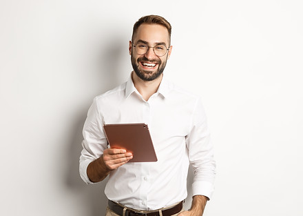 confident-business-man-holding-digital-tablet-smiling-standing-against-white-background.jp