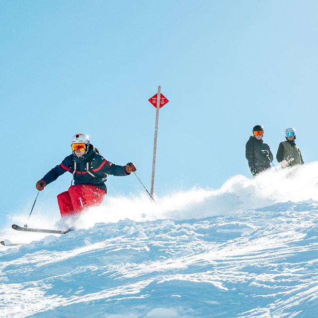 Skiers during a group lesson on a snowy slope