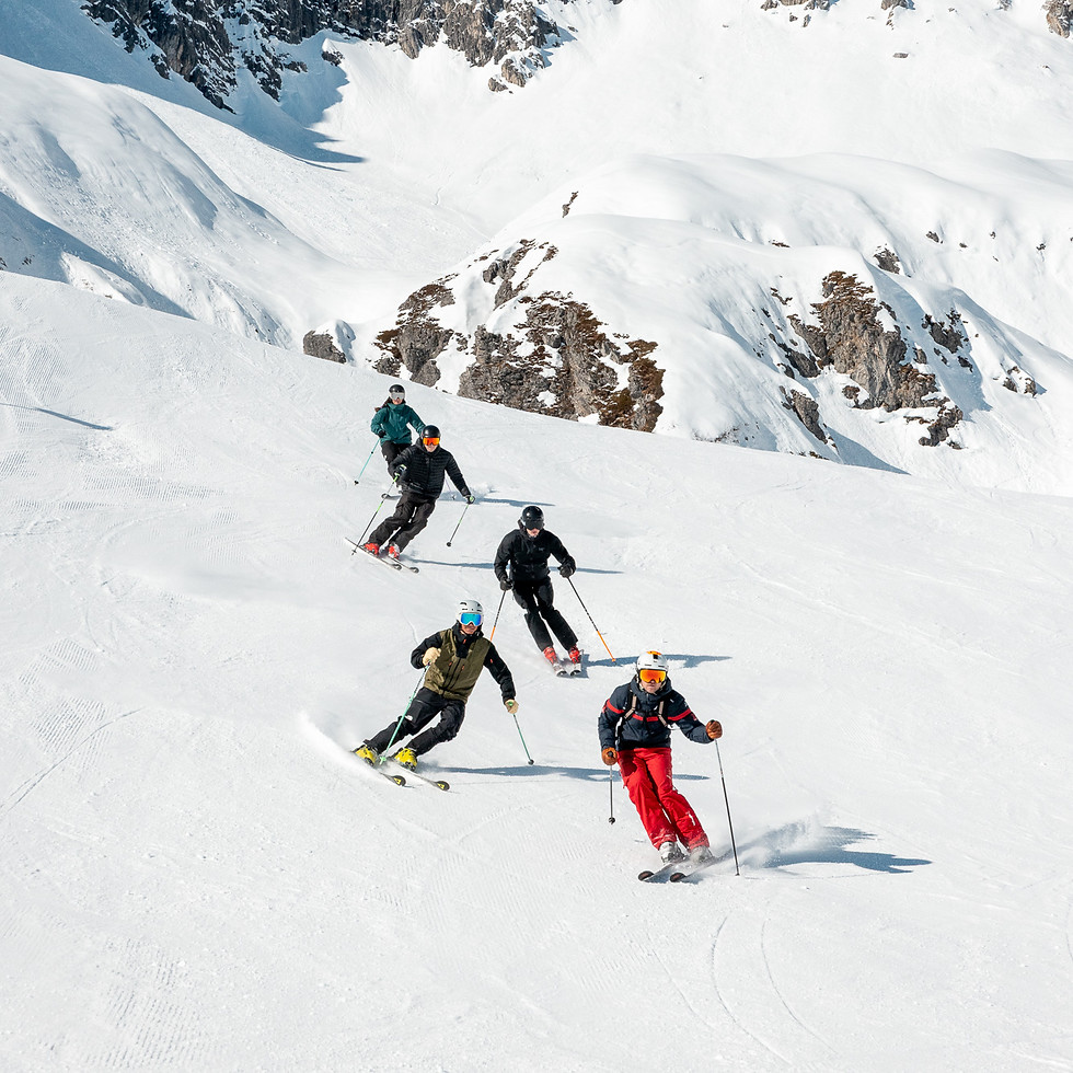 Skiers during a group lesson on a snowy mountain slope
