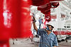 male-factory-worker-spray-painting-a-red-crane-in-2024-10-18-09-20-28-utc.jpg