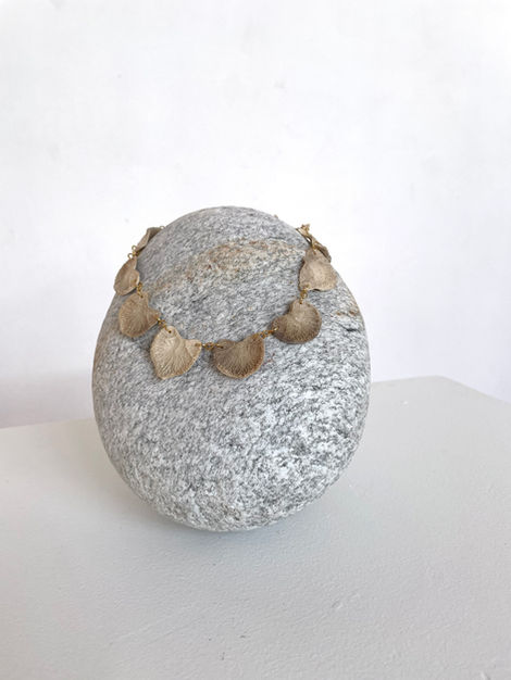 sculpture, in memoriam, os trouvés, disques intervertébraux, métal doré et granit, 18 x 17 x 18 cm, 2024