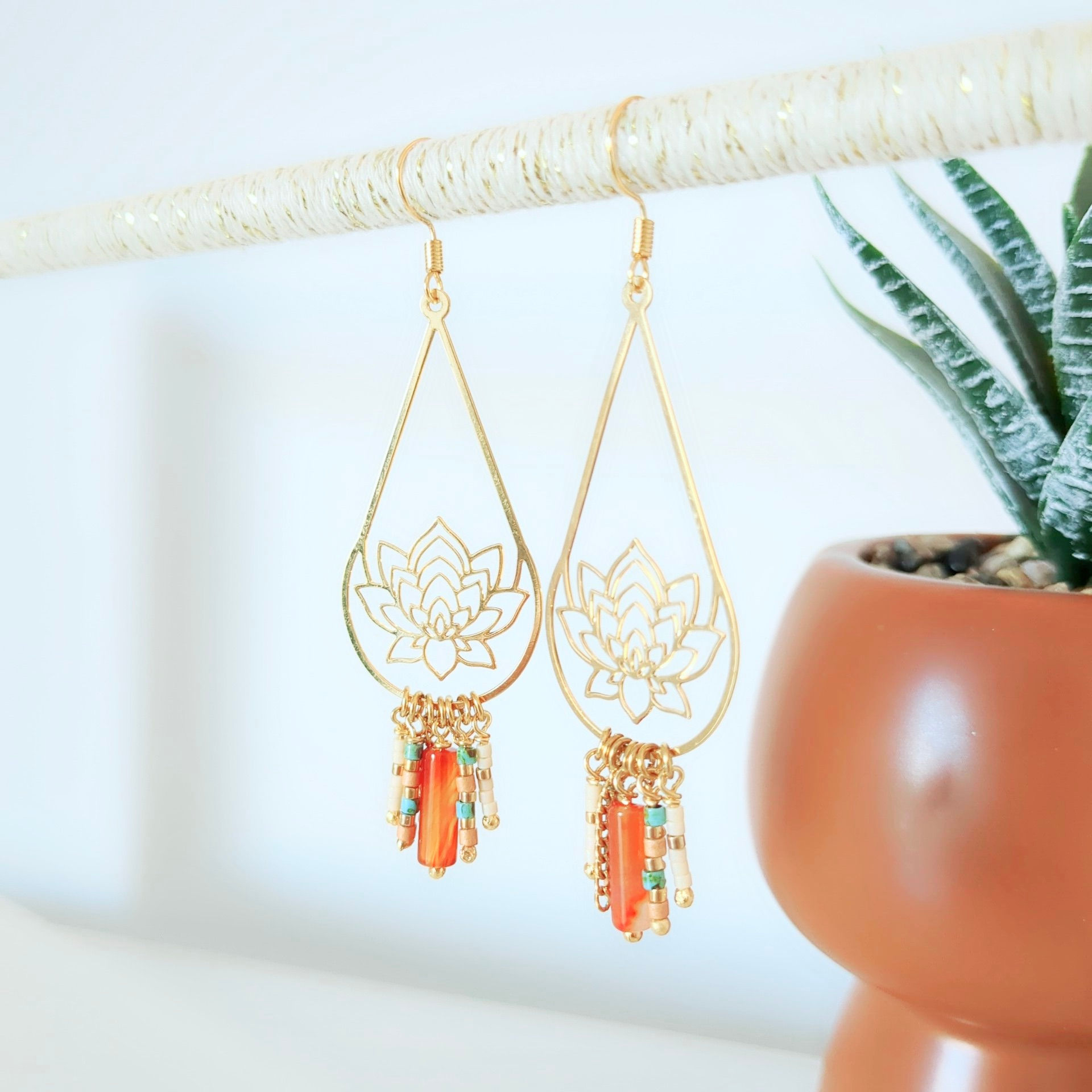 Boucles d'oreilles ISALYS fleur de lotus dorée, perles corail orangé et turquoise. Une création artisanale bohème chic, lumin