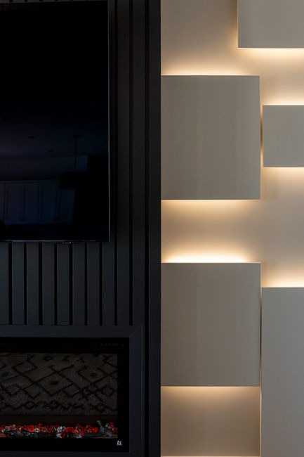 closeup of Bold Fireplace buildout with modern lighting in living room