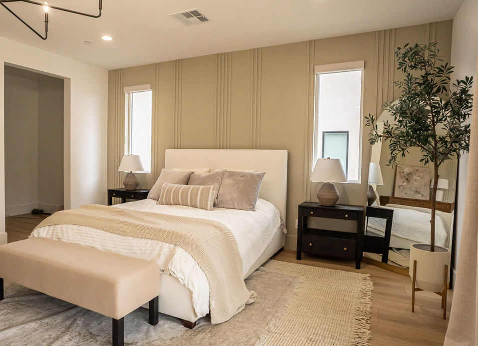 Custom wood accent wall in a modern primary bedroom by Selhorst Woodworks, with vertical slats and neutral furnishings.