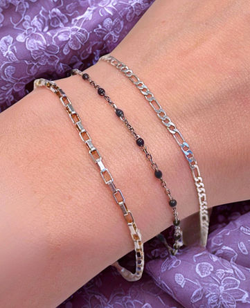 Three-tiered sterling silver stack bracelet with black beaded chain in the middle