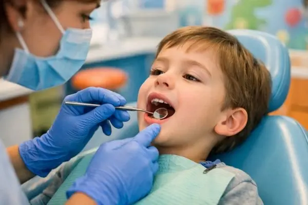 Pediatric dentist checking baby teeth during a dental exam