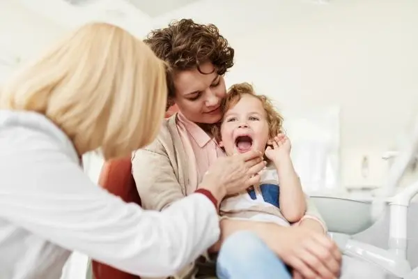 Pediatric dentist examining child’s teeth
