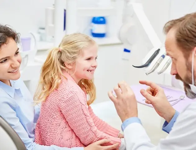 2. Pediatric dentist explaining a dental procedure to a child.webp