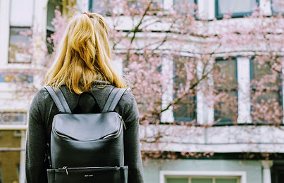 Student with backpack looking at a university building