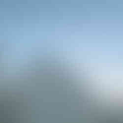 White Greek Chruch in Paros, Greece, with the blue top and a cross at the top, the sky is clear and blue behind the dome.