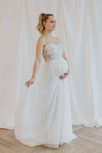 Schwangere Braut in Corsagen-Brautkleid mit Tüllrock