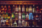 différentes bouteilles d'alcool derrière un bar