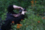 A photographer bends over backwards to get a great shot of red wildflowers in Alberta SouthWest.