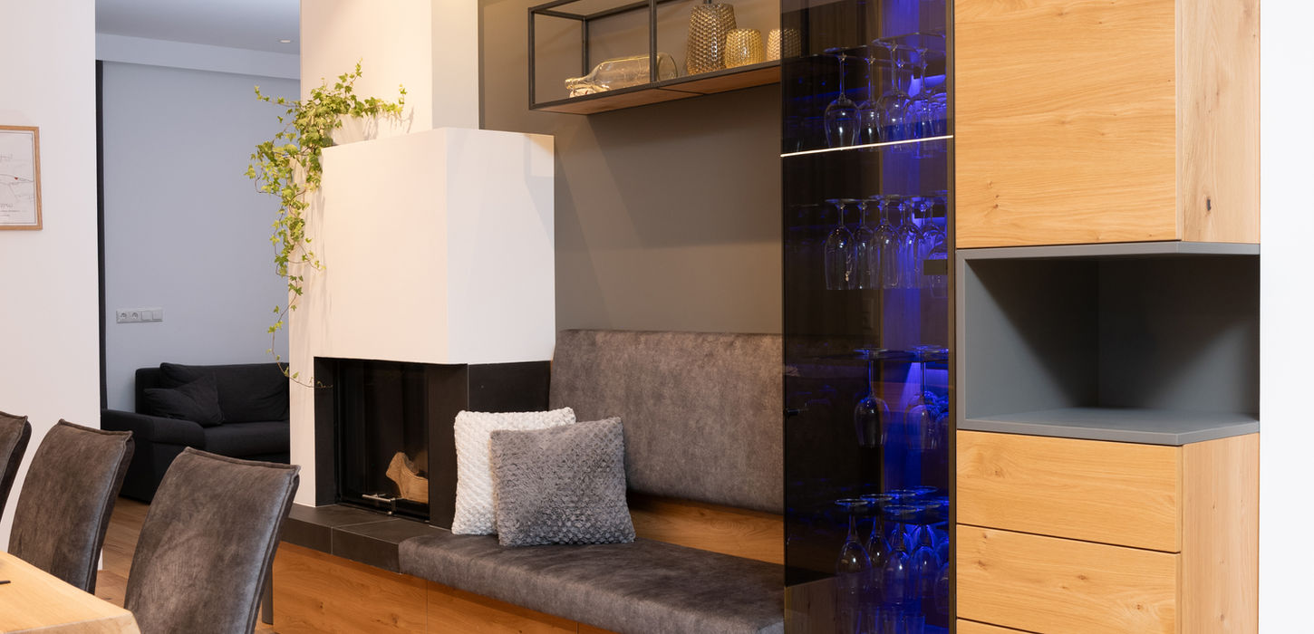 Wohnbereich mit Ofenbank und Weinglasschrank