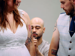 Bride and groom getting matching wedding day fingerprint heart tattoos by a creative Liverpool tattoo artist at Creato Tattoo Studio