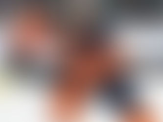 ChatGPT said:  Hockey player in an orange uniform skating with the puck, showing strong edge control and low athletic posture during game play.