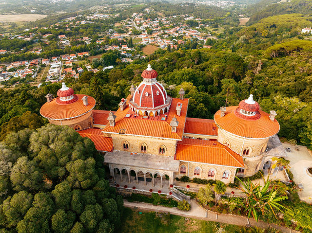 Breathtaking aerial capture of the historic Monserrate Palace surrounded by lush greenery in Sintra, Portugal.