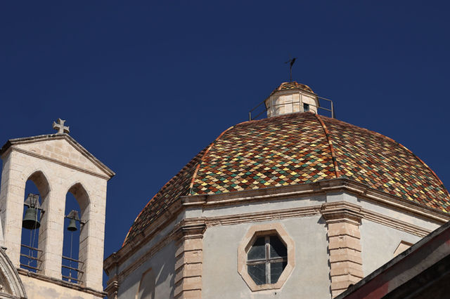 A striking view of the colorful dome of Cagliari Cathedral in Sardinia, Italy.
