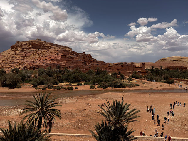 Scenic landscape of Ait Benhaddou, Morocco with dramatic clouds and desert scenery.