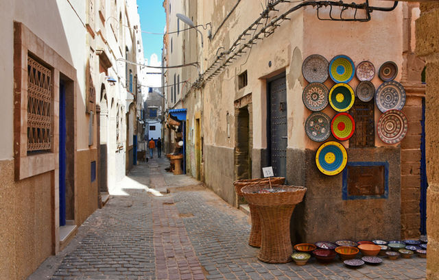 Colorful pottery adorns an alleyway in historic Essaouira, offering a glimpse into Moroccan culture.