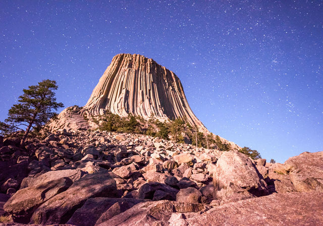 A mountain with a star filled sky above it