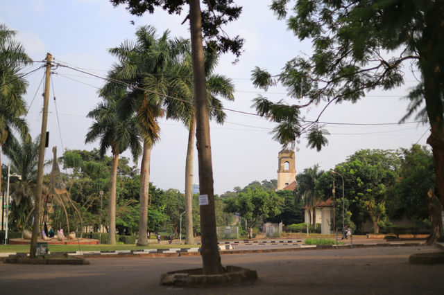 a street with palm trees and a clock tower in the background