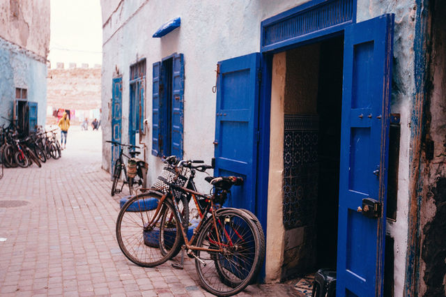 Discover the vibrant blue doors and bicycles in the narrow alleyways of Essaouira, Morocco.