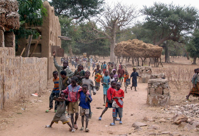 A group of people walking down a dirt road