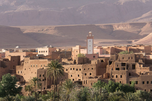 A village in the desert with mountains in the background
