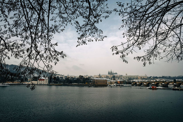 Scenic winter view of Prague Castle and Charles Bridge across the river.