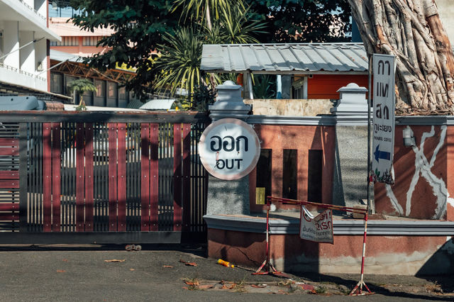 Street scene in Chiang Mai, Thailand featuring an 'Out' sign in Thai and English.