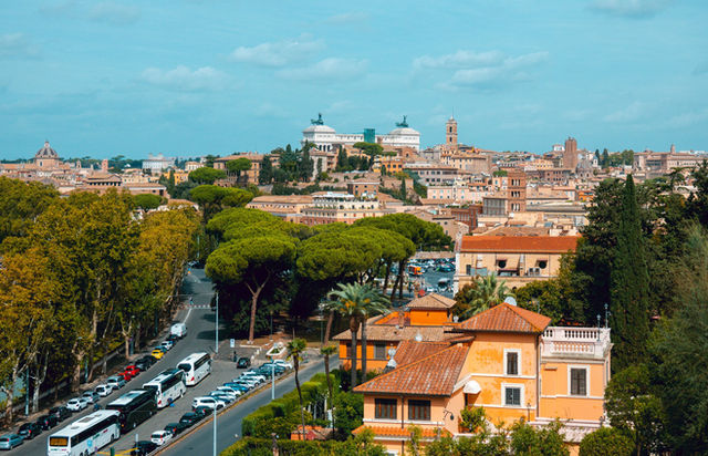 Stunning aerial view of Rome showcasing historic architecture and lush greenery under a clear sky.