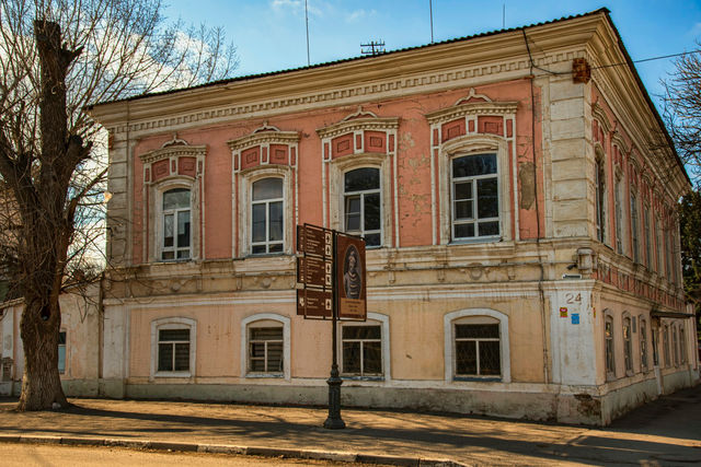 A pink and yellow historic building with ornate windows