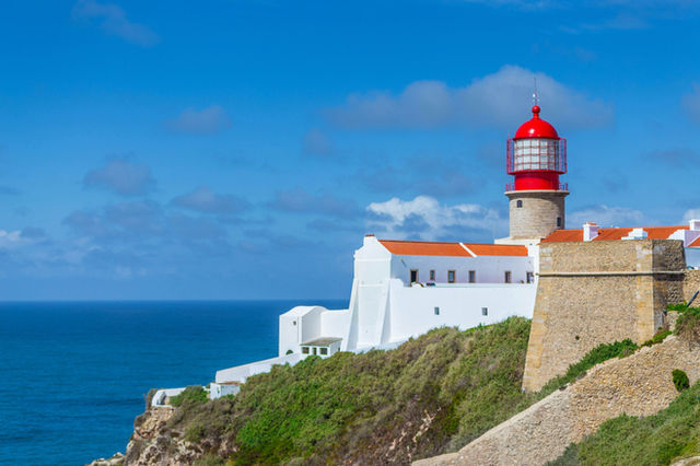 white, red, and brown lighthouse by the sea during daytime