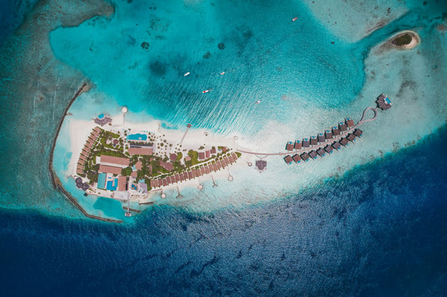 Aerial view of a tropical island resort and turquoise ocean.