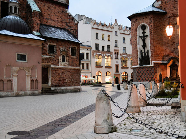 Explore the historical charm of Kraków's Old Town, featuring vintage brick buildings and cobblestone streets.